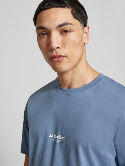 Männermodel trägt T-Shirt mit Logo und Rundhalsausschnitt von Jack & Jones in Blau, reine Bio-Baumwolle, Nahaufnahme Oberkörper.