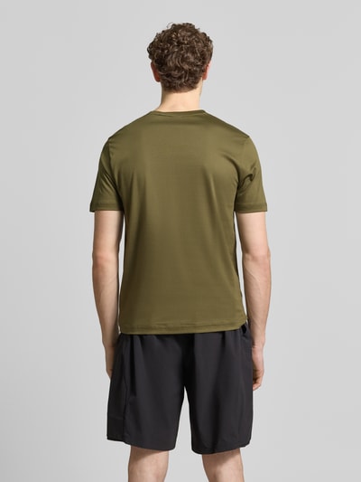 Męski model nosi Regular Fit T-Shirt aus reiner Baumwolle Modell 'PS Spirit 70 Grx' od BOSS Green X PORSCHE, oliwkowy, prosty krój, krótkie rękawy, okrągły dekolt, materiał 4way stretch, jednolity kolor, aplikacja z logo, widok całej sylwetki z tyłu.