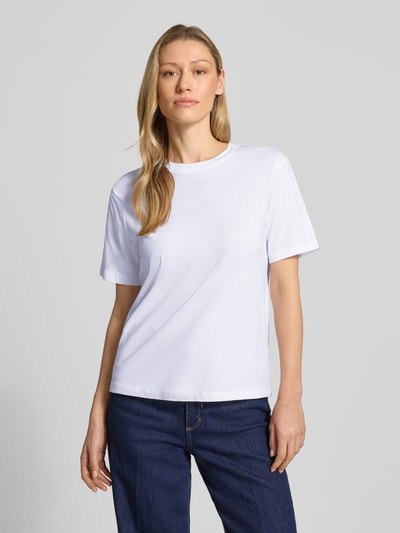Modelka kobieca ma na sobie damski t-shirt z bawełny ekologicznej od Jake*s Casual, prosty krój, okrągły dekolt, długość tyłu w rozmiarze S: 58 cm, widok całej sylwetki z przodu.