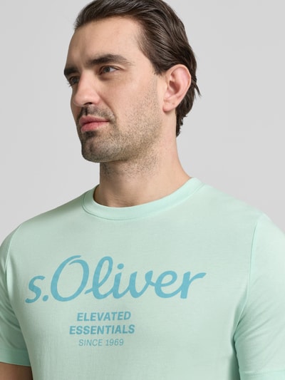 Mężczyzna nosi Regular Fit T-Shirt aus reiner Baumwolle von s.Oliver RED LABEL z nadrukiem, kolor miętowy, krój regular fit, materiał jersey, widok z przodu, zbliżenie na górną część ciała.