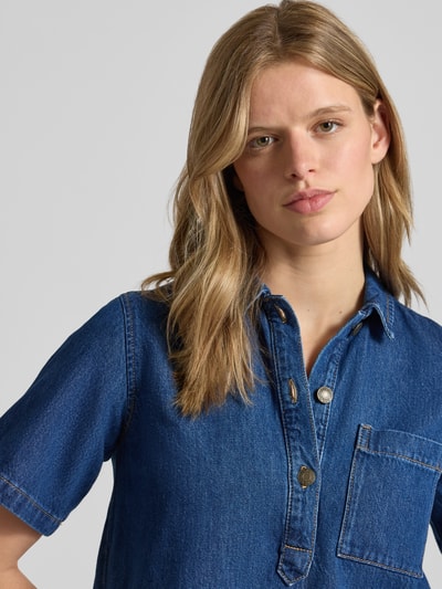 Frauenmodel trägt Relaxed Fit Minikleid in Denim-Optik Modell 'Amara' von JJXX, reine Baumwolle, kurzärmelig, Nahaufnahme Oberkörper.