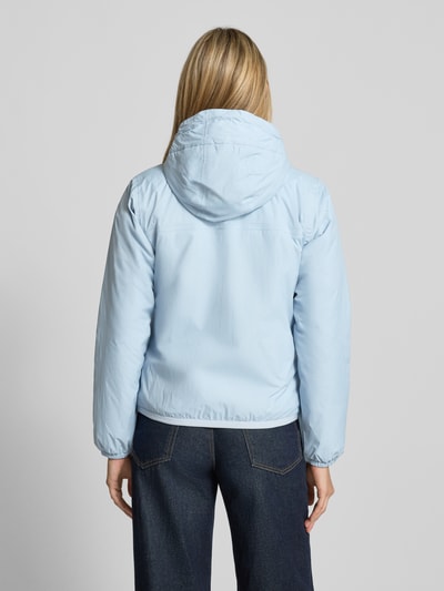 Frauenmodel trägt Regular Fit Jacke mit Logo-Print Modell 'CLAUDETTE' von K-WAY in Hellblau, glatte Struktur, elastische Abschlüsse, Kapuze mit Tunnelzug, Rückenlänge 59 cm, Schulterbreite 39 cm, Brustweite 51 cm, Ärmellänge 63 cm, Ganzkörperansicht Rückansicht