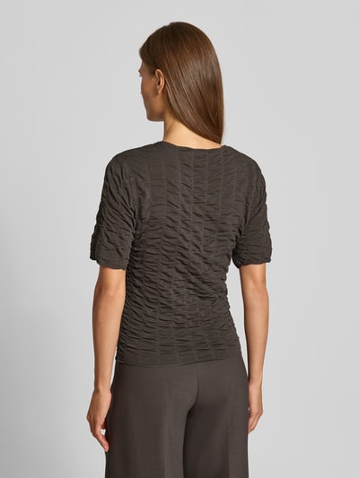 Frauenmodel trägt Slim Fit T-Shirt aus Viskose-Mix Modell 'NATACHA' von Cph Muse, Strukturmuster, dunkel, Ganzkörperansicht Rückansicht.