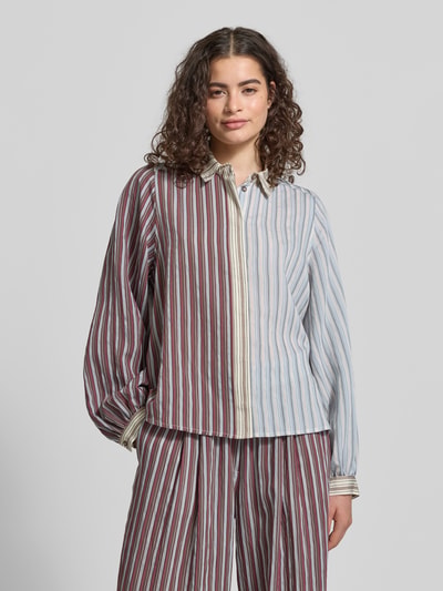 Frauenmodel trägt Relaxed Fit Bluse aus Lyocell-Mix von Jake*s Casual mit Allover-Look, Hemdblusenkragen, verdeckter Knopfleiste, gestreiftes Muster in Blau und Rot, Textur weich und fließend, Rückenlänge 60 cm, Ärmellänge 63 cm, Nahaufnahme Oberkörper.