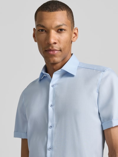 Männermodel trägt Slim Fit Business-Hemd mit Kentkragen von OLYMP Level Five aus Reine Baumwolle, hellblau, Nahaufnahme Oberkörper. Rückenlänge 70 cm, Schulterbreite 40 cm, Ärmellänge 24 cm, Knopfleiste, Ärmel mit Aufschlag.