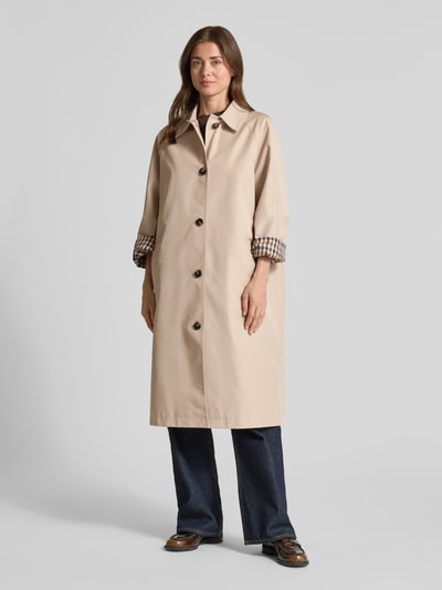Frauenmodel trägt Taillierter Trenchcoat mit Innenmuster von Jake*s Collection in Beige mit Knopfleiste, Hemdblusenkragen und Taillengürtel, Material-Mix mit Woll-Anteil, Eingrifftaschen, glatte Textur, Ganzkörperansicht von vorne.