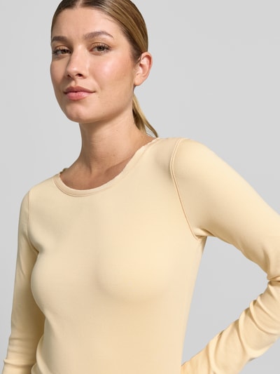 Kobiece model nosi Longsleeve aus Baumwoll-Mix von Marc Cain w kolorze jasnego beżu, krój slim fit, okrągły dekolt, mieszanka bawełny i elastanu, długość tyłu w rozmiarze 36: 50 cm, zbliżenie na górną część ciała