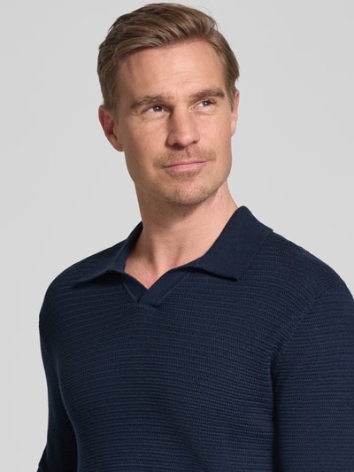 Männermodel trägt Regular Fit Poloshirt in Strick-Optik Modell 'Riley' von Jack & Jones Premium, reine Baumwolle, Nahaufnahme Oberkörper.