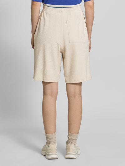 Vrouwenmodel draagt Sweatshorts met steekzakken en logo-stitching model 'FUXOW' van American Vintage, katoen, loose fit, elastische tailleband, Franse steekzakken, binnenbeenlengte maat S 24 cm, achterkant volledige lichaamsweergave.