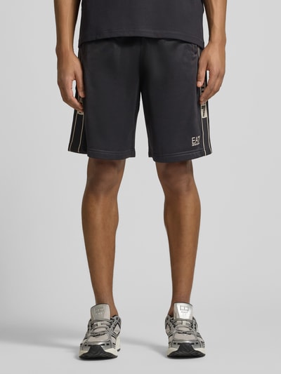 Männermodel trägt Shorts mit Logo und Eingrifftaschen von EA7 Emporio Armani in Relaxed-Fit, elastischer Bund, Vorderansicht, Nahaufnahme Unterkörper.