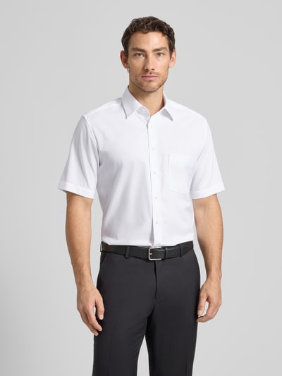 Männermodel trägt Regular Fit Business-Hemd aus Baumwolle mit Kentkragen von ETERNA, Weiß, Brusttasche, Ganzkörperansicht von vorne. Rückenlänge bei Größe 40: 80 cm, Schulterbreite bei Größe 40: 45 cm, Ärmellänge bei Größe 40: 28 cm.