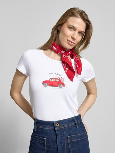 Kobiece modelka nosi T-shirt mit Motiv-Print und Pailletten von More & More, mieszanka bawełny i elastanu, krój regular fit, nadruk z motywem, cekiny, okrągły dekolt, długość tyłu w rozmiarze 36: 60 cm, widok całej sylwetki z przodu.