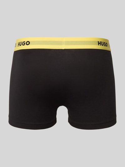 Männermodel trägt Slim Fit Trunks aus Baumwoll-Mix im 3er-Pack Modell 'PACK' von HUGO, unifarben, elastischer Bund, Rückansicht.