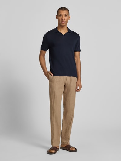 Męskimodel nosi koszulkę polo Slim Fit Poloshirt mit Logo-Detail model 'Boll' von CINQUE z czystej bawełny, krój slim fit, krótki rękaw, kołnierzyk polo, elastyczne zakończenia rękawów, długość tyłu w rozmiarze M: 66 cm, widok całej sylwetki z przodu.