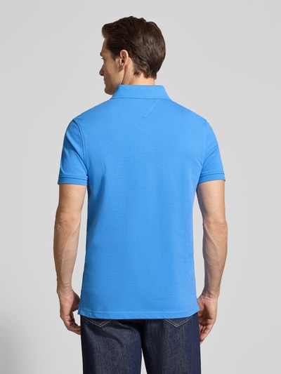 Männermodel trägt Regular Fit Poloshirt aus Baumwoll-Mix von Tommy Hilfiger, Optik: Unifarben, Logo-Stitching, Ganzkörperansicht Rückansicht.
