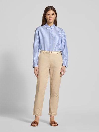 Frauenmodel trägt Casual Fit Chino mit Baumwoll-Anteil von Christian Berg Woman in Beige, mit Gürtel und Seitentaschen, Ganzkörperansicht von vorne.
