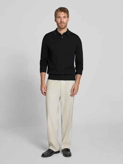 Männermodel trägt Regular Fit Poloshirt in Strick-Optik von Paul Smith in Schwarz, reine Wolle, Langarm, Polokragen, Label-Stitching, gerippte Abschlüsse, Rückenlänge 67 cm, Ganzkörperansicht von vorne.