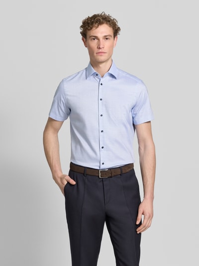 Männermodel trägt Regular Fit Business-Hemd mit Kentkragen von Christian Berg Men, Reine Baumwolle, Knopfleiste, Kurzärmelig, Ganzkörperansicht von vorne.
