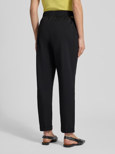 Frauenmodel trägt Straight Fit Stoffhose mit Viskose-Anteil von LIU JO SPORT, schwarzer Material-Mix, elastischer Bund, Zierbesatz, 7/8-Länge, Ganzkörperansicht Rückansicht.