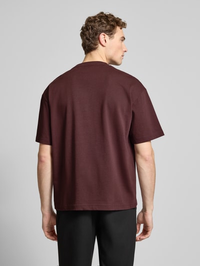 Männermodel trägt Oversized T-Shirt aus reiner Baumwolle Modell 'DINKEE' von HUGO in Uni-Bordeaux, Rundhals, Rückansicht, Ganzkörperansicht