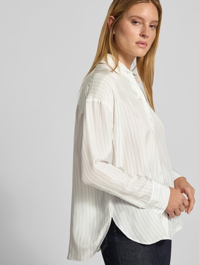 Frauenmodel trägt Gestreifte Bluse aus Viskose - curated by Viky Rader von Style Icon Collection in Weiß mit feinen Streifen, Relaxed Fit, Hemdblusenkragen, durchgehende Knopfleiste, überschnittene Schultern, 1-Knopf-Manschetten, glatte Textur, Seitenansicht obere Körperhälfte.