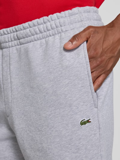 Männermodel trägt Relaxed Fit Sweatshorts aus katoenmix von Lacoste in lichtgrijs met zichtbare textuur, Nahaufnahme Oberkörper. Heren Sweatshorts van Lacoste.