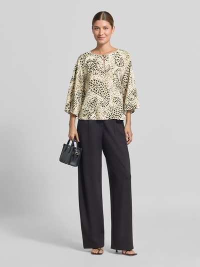 Vrouwenmodel draagt Relaxed Fit blouse met korte mouwen uit pure viscose van s.Oliver BLACK LABEL met licht beige en zwarte print, volledigegaanzicht van voren.