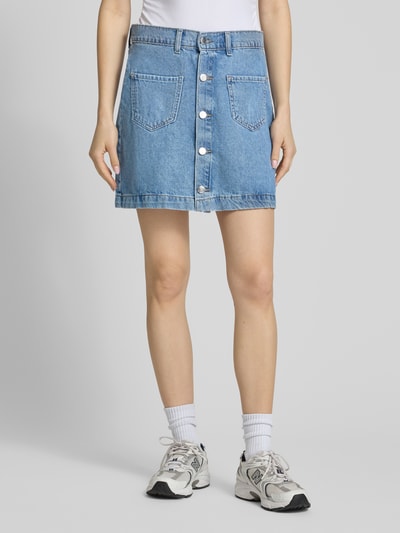 Frauenmodel trägt Schmaler Jeansrock aus reiner Baumwolle Modell 'AMAZING' von Only in Denim-Optik mit Kontrastnaht, Mini-Länge, Ganzkörperansicht von vorne.