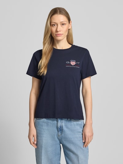 Frauenmodel trägt T-Shirt mit Rundhalsausschnitt und Label-Stitching von Gant, Reine Baumwolle, Regular-Fit, Rückenlänge 57 cm, Ganzkörperansicht von vorne.