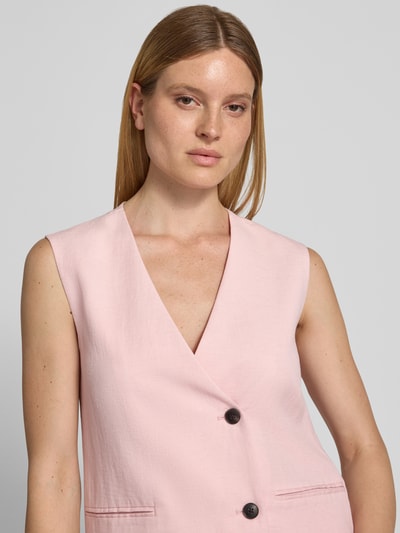 Frauenmodel trägt Oversized Weste aus Viskose-Lyocell-Mix Modell 'Franciska' von MSCH Copenhagen, zartrosa, leicht strukturierte Oberfläche, 2-Knopfleiste, Paspeltaschen, Nahaufnahme Oberkörper. Rückenlänge bei Größe S: 69 cm, Schulterbreite: 39 cm, Brustweite: 46 cm, Leinen-Anteil.