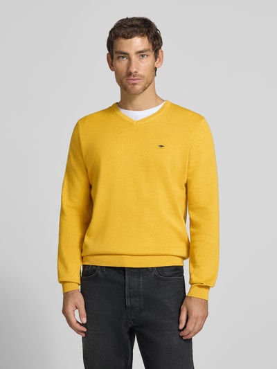 Männermodel trägt Strickpullover mit Label-Strickerei von Fynch-Hatton in Gelb, reine Baumwolle, gerader Schnitt, V-Ausschnitt, Ganzkörperansicht von vorne
