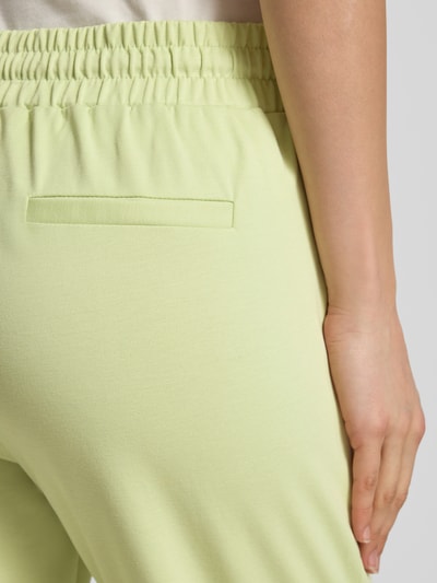 Frauenmodel trägt Sweatpants mit Tunnelzug Modell 'KATE' von ICHI in Hellgrün, Material-Mix mit Viskose-Anteil, Nahaufnahme Rückansicht.