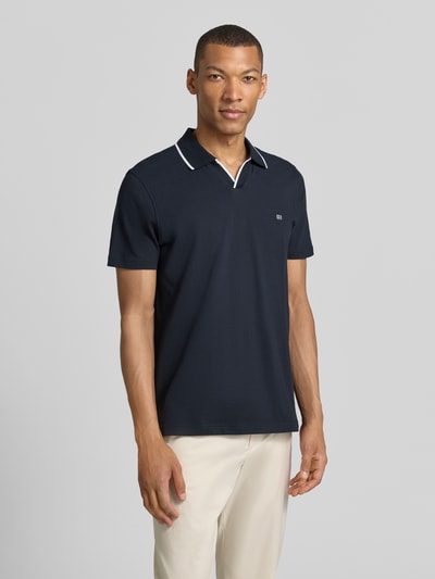 Męski model nosi Modern Fit Poloshirt mit Logo-Stitching von Christian Berg Men, bawełna, krój modern fit, kolor granatowy, widok całej sylwetki od przodu.