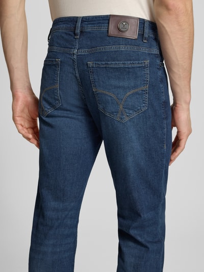 Männermodel trägt Modern Fit Jeans Modell 'Fortress' von JOOP! Collection in Blau, Baumwoll-Elasthan-Mix, Ganzkörperansicht Rückansicht.