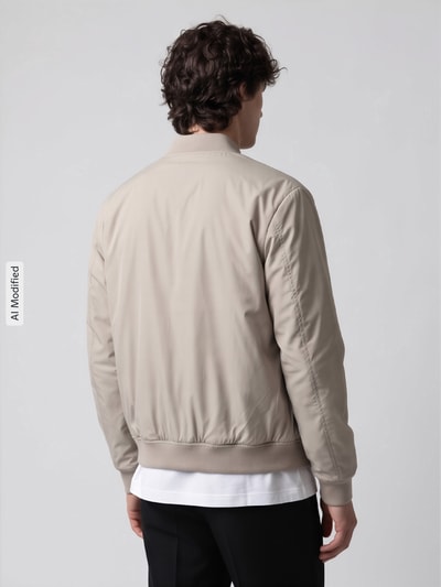 Männermodel trägt beigefarbene Regular Fit Bomberjacke mit Baseball-Kragen Modell 'CHARLES' von Selected, Ganzkörperansicht Rückansicht, KI-modifiziertes Bild. Herren Bomberjacke / Blouson.