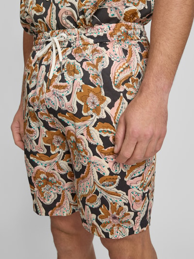 Männermodel trägt Relaxed Fit Shorts aus Lyocell Modell 'FAVE' von Scotch & Soda mit Allover-Look, elastischer Bund, Nahaufnahme Oberschenkel.