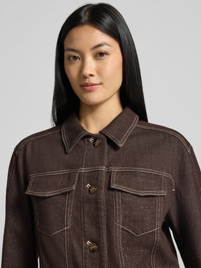 Frauenmodel trägt Jeansjacke mit Brusttaschen und Knopfleiste von Marc Cain, Baumwoll-Mix mit Viskose-Anteil, Nahaufnahme Oberkörper.
