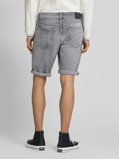 Męski model prezentuje Regular Fit Jeansshorts aus Baumwoll-Mix od Tommy Jeans, stylizowana na denim, naszywka z logo, wyhaftowane logo, szlufki na pasek, zapięcie na guzik i ukryty zamek błyskawiczny, 5 kieszeni, mieszanka bawełny, widok całej sylwetki od tyłu.