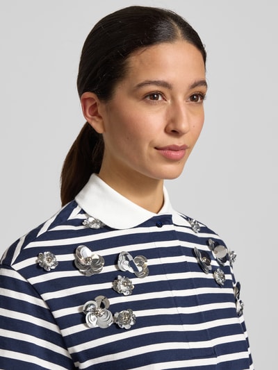 Frauenmodel trägt T-Shirt mit Polokragen von Rich & Royal in Dunkelblau-Weiß gestreift, reine Baumwolle, Zierbesatz, Nahaufnahme Oberkörper.