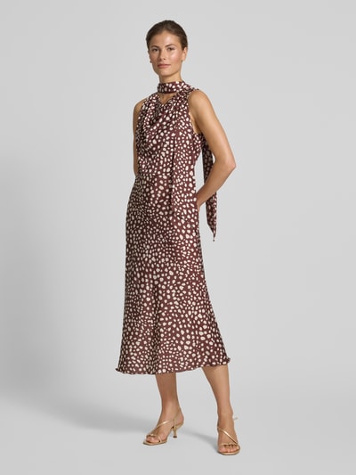 Vrouwenmodel draagt Midikleid mit Stehkragen van Rinascimento, bruin met witte stippen, getailleerde pasvorm, mouwloos, elastische materiaalmix, lengte 122 cm, borstwijdte 48 cm, Ganzkörperaanzicht van voren.