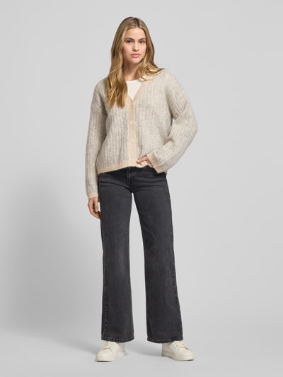 Frauenmodel trägt Relaxed Fit Strickjacke aus Woll-Mix mit Alpaka-Anteil Modell 'FALVA' von Selected Femme, Optik:Allover-Muster, Strukturmuster, einreihige Knopfleiste, Crew Neck, V-Ausschnitt, Langarm, gerippter Abschluss, Strick, Ganzkörperansicht von vorne.