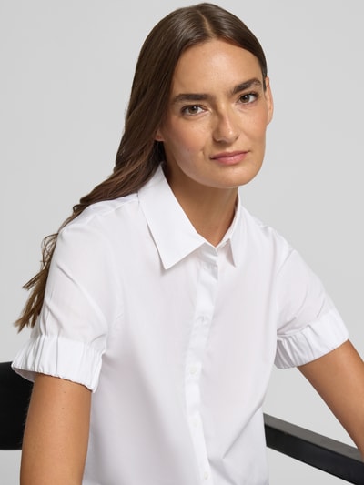 Kobiece modelka nosi białą bluzkę z krótkim rękawem Regular Fit z bawełny model 'EFFRY' od HUGO, damska Kurzarmbluse, zbliżenie na górną część ciała.