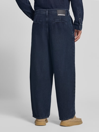 Männermodel trägt dunkelblaue Baggy Jeans aus reiner Baumwolle Modell 'Kaavo' von ARMEDANGELS, lockerer Schnitt, Herren Baggy Jeans, Ganzkörperansicht Rückansicht