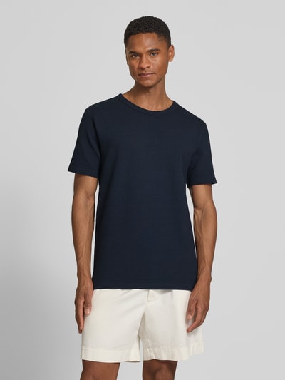 Männermodel trägt Regular Fit T-Shirt aus Baumwoll-Mix Modell 'SANDER' von SELECTED HOMME in Unifarbe, Struktur Seersucker, Ganzkörperansicht von vorne.
