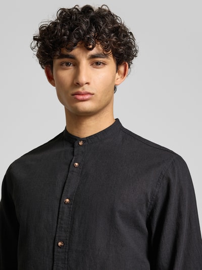 Männermodel trägt Regular Fit Freizeithemd aus Baumwoll-Leinen-Mix von Jack & Jones in Schwarz mit Stehkragen und Knopfleiste, Nahaufnahme Oberkörper. Rückenlänge 75 cm, Schulterbreite 46 cm, Ärmellänge 65 cm, Modell SUMMER LINEN BLEND für Herren.