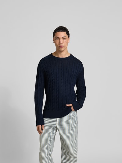 Männermodel trägt Slim Fit Pullover in Strick-Optik von Filippa K, dunkelblau, reine Baumwolle, Rundhalsausschnitt, Ganzkörperansicht von vorne.