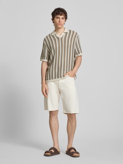 Männermodel trägt Regular Fit Poloshirt aus Baumwoll-Mix Modell 'THUE' von Only & Sons mit gestreiftem Lochstrickmuster, Ganzkörperansicht von vorne.