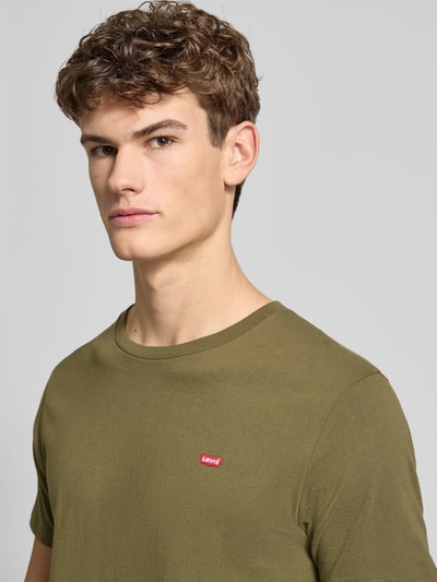 Männermodel trägt T-Shirt mit Label-Stitching von Levi's®, reine Baumwolle, Regular-Fit, gerippter Rundhalsausschnitt, Nahaufnahme Oberkörper.
