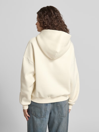 Frauenmodel trägt Relaxed Fit Sweatshirt mit Logo-Print von Review aus Baumwoll-Mix mit Känguru-Tasche, elastische Abschlüsse, Ganzkörperansicht Rückansicht.