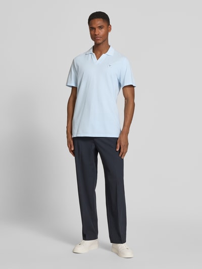 Mężczyzna nosi Regular Fit Poloshirt aus reiner Baumwolle od s.Oliver RED LABEL, gładki jasnoniebieski, krój regular fit, aplikacja z logo, kołnierz polo, dekolt w serek, krótki rękaw z ściągaczem, dół z rozcięciami po bokach, tkanina pique, czysta bawełna, widok całej sylwetki z przodu.